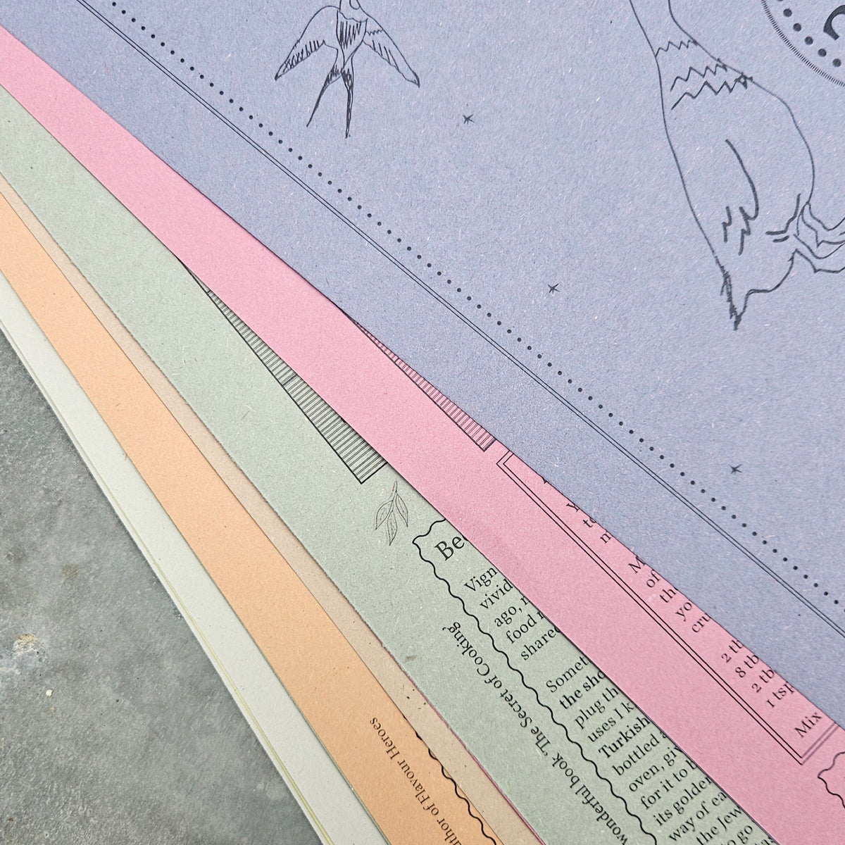 Edges of the calendar's lavender, pink, green, peach and cream papers