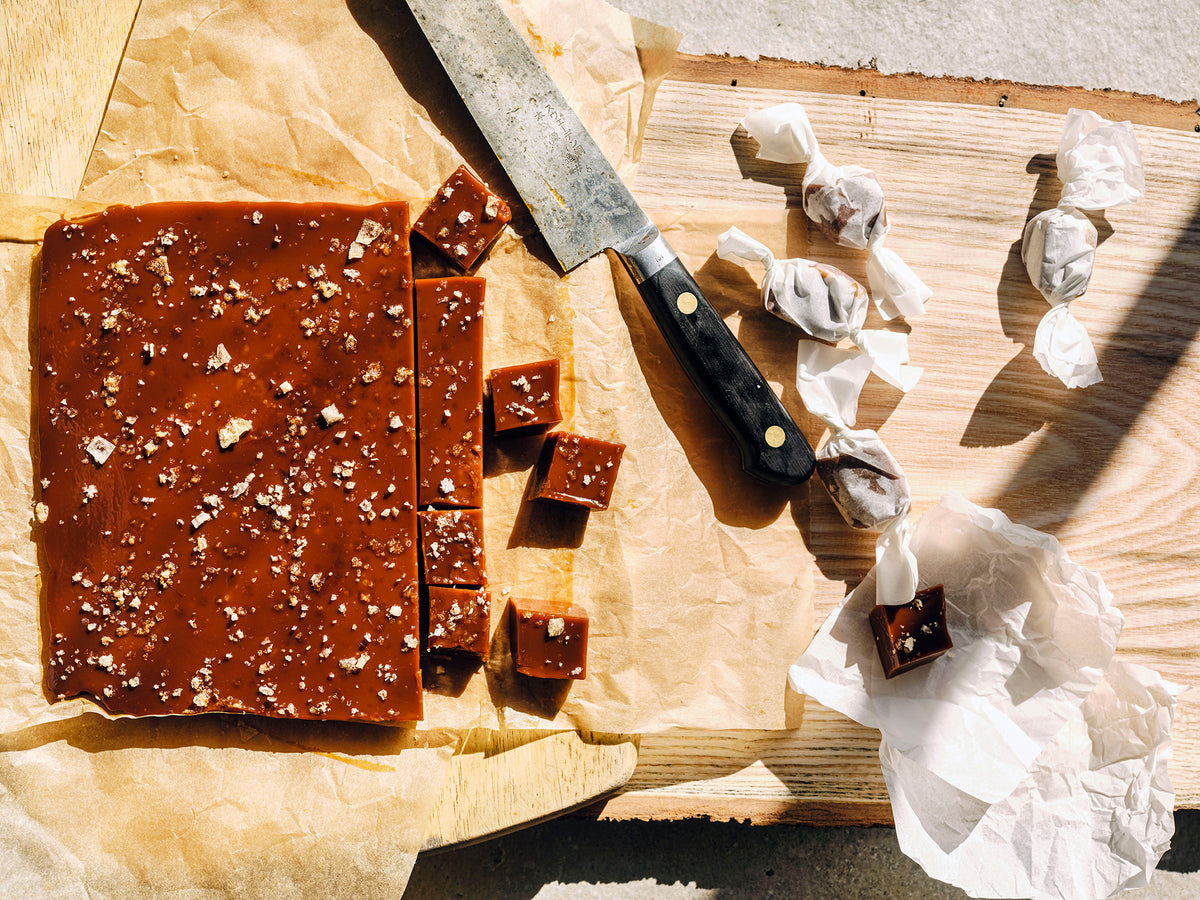 Scotch caramels scattered with sea salt, being cut and wrapped